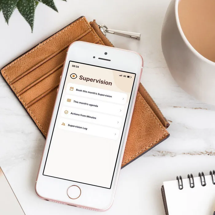 Mentoring mobile app shown on an iPhone resting on a leather wallet